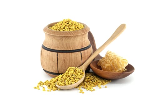 A rustic setup featuring a wooden barrel containing bee pollen, a spoon, and a bowl with a honeycomb for a natural and wholesome aesthetic.