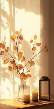 Warm sunlight casts shadows on autumn leaves in a glass vase, accompanied by candles and a lantern on a wooden table.