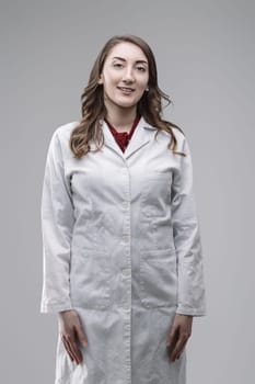 Portrait of a confident young female scientist smiling at the camera while wearing a lab coat, showcasing her expertise and passion for scientific research