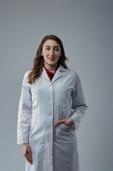 Young woman scientist wearing a lab coat stands confidently with her hand in her pocket, exuding professionalism and expertise in a scientific setting
