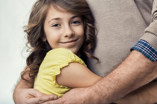 Young daughter embracing her father, arms wrapped around him in a heartwarming display of love and trust, highlighting the deep familial bond shared between them