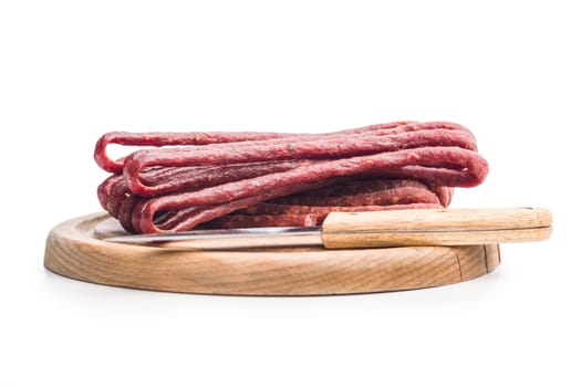 Smoked kabanos. Mini dried thin sausages on a cutting board isolated on white background