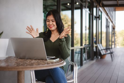 Business woman working from coffee shop using laptop online meeting in home office, Business woman typing keyboard use notebook laptop Smiling, laughing at coffee shop relaxation table.
