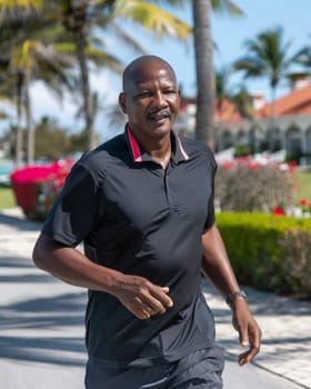 A mature, smiling African-American man walking amidst lush palm trees and tropical foliage, embodying a sense of tranquility and relaxation in the warm, vibrant setting