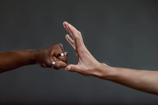 One hand is forming a fist, while the other hand is open, creating a sense of tension and uncertainty about whether a handshake, fist bump, or conflict will ensue