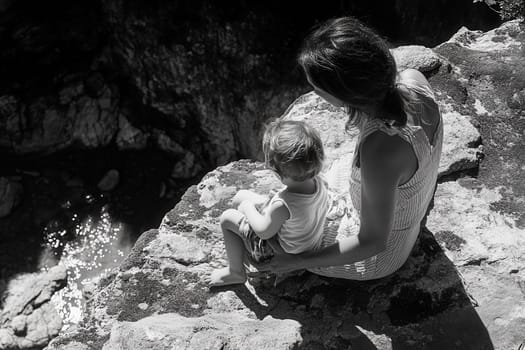 Mother and son sitting on a cliff enjoying a moment of contemplation while observing a suggestive panorama
