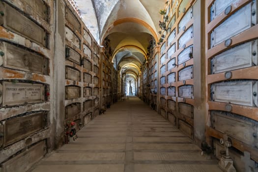 Genoa, Italy - August 17, 2024: Staglieno cemetery. Corridor perspective with old tombs, no people.