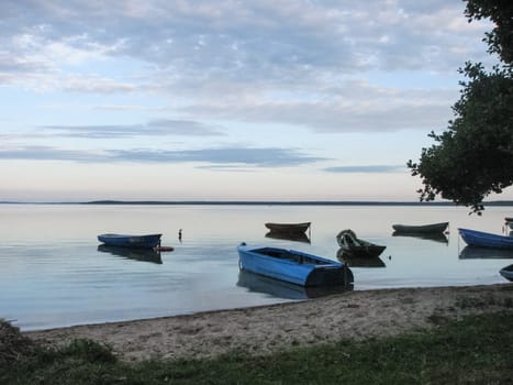 Lots of wooden boats by the lake. Boat mooring.