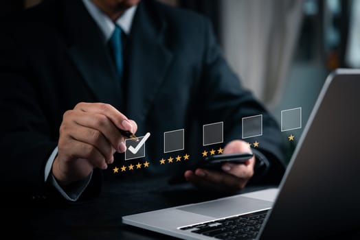 Person selecting a rating star on a laptop, symbolizing customer satisfaction, quality assessment, and feedback. Useful for customer service, product reviews, and business quality control.