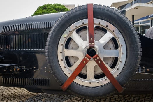 Lisbon, Portugal - Oct 15, 2023: Side view of boat tail bonnet and spare tyre of vintage Pur Sang Bugatti Type 35 car on overcast day. Bugatti Type 35 is race car class, Grand Prix icon of 1920s, by Bugatti, France, first car with alloy wheels.