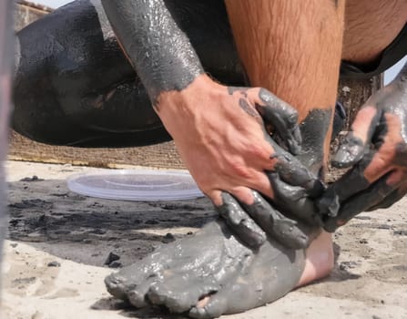 People are wiped with mud. Mud baths in Spain.