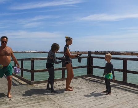 Alicante, Spain - July 24, 2019: People are wiped with mud. Mud baths in Spain.