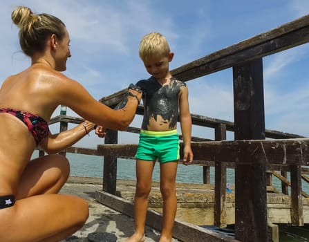 Alicante, Spain - July 24, 2019: People are wiped with mud. Mud baths in Spain.