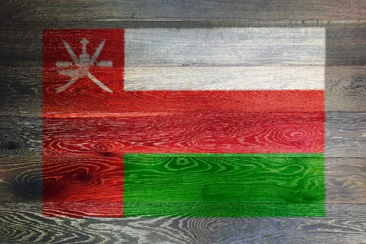 An Oman flag on rustic old wood surface background red white green dagger swords