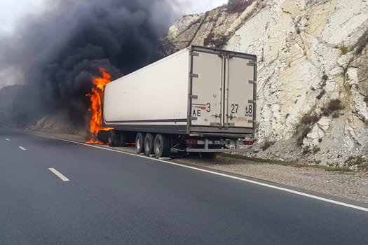 Burning truck on the road. The cab of the truck is on fire.