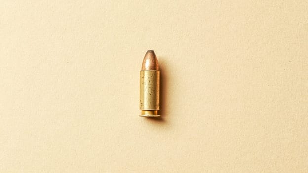 Single bullet cartridge lying on a neutral background, representing concepts of danger, violence, and ammunition, with potential use in crime related themes