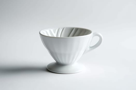 A delicate porcelain coffee dripper stands alone on a clean surface, emphasizing its graceful curves and simplicity in design.