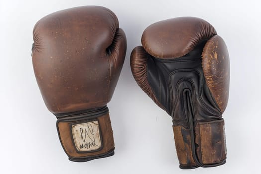 This pair of well-worn boxing gloves displays signs of usage, telling a story of training, competition, and athletic passion.