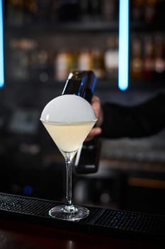 barman is making cocktail with smoky air bubble at the bar