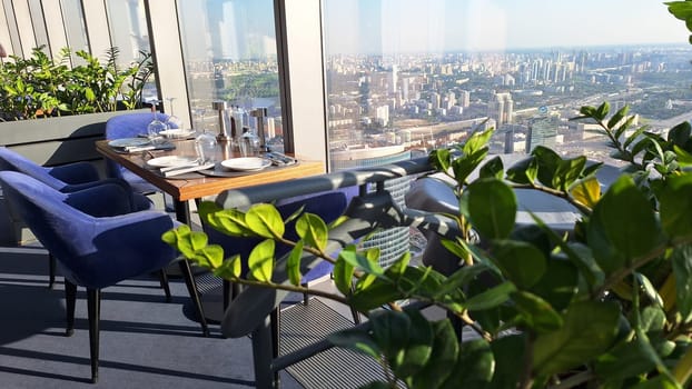 Modern rooftop dining with scenic cityscape views on a sunny day.