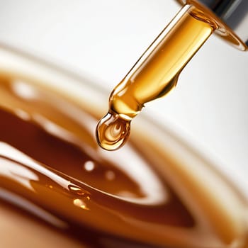 Golden liquid dripping from dropper: concept of beauty and skincare