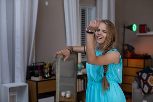 A cheerful girl in a lovely blue dress poses at home, creating a fun and warm atmosphere filled with joy