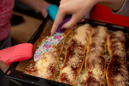 A hand slices through cheesy enchiladas topped with rich sauce and melty cheese, ideal for sharing meals