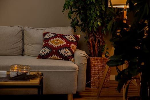 A modern living room that features a comfortable sofa adorned with colorful cushions and lush, vibrant plants