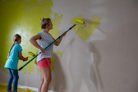 A cheerful family paints a wall bright yellow, engaging in a fun home improvement project filled with joy