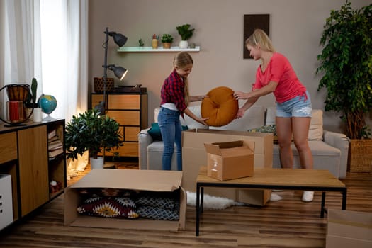 A cheerful family comes together to enjoy unpacking and organizing their new and cozy living room space