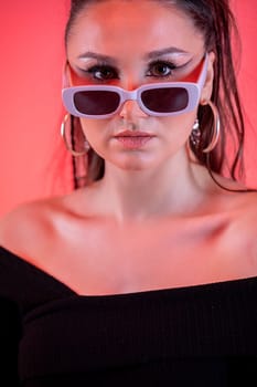 A trendy fashion model confidently showcases bold sunglasses and a striking look bursting with bright hues