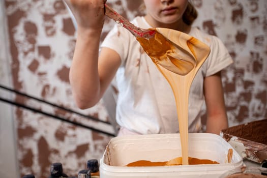 A young artist mixes vibrant colors, showcasing their creativity and playful expression through art