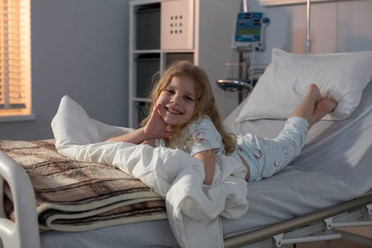 A cheerful young girl beams with joy while comfortably lying in a hospital bed, illustrating her incredible resilience