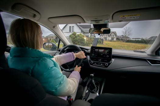 A woman grips the steering wheel, excited for an adventure through the breathtaking scenic countryside