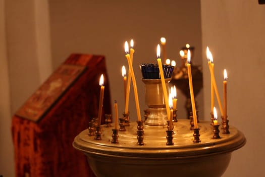 Burning candles in a tranquil church setting with soft lighting.