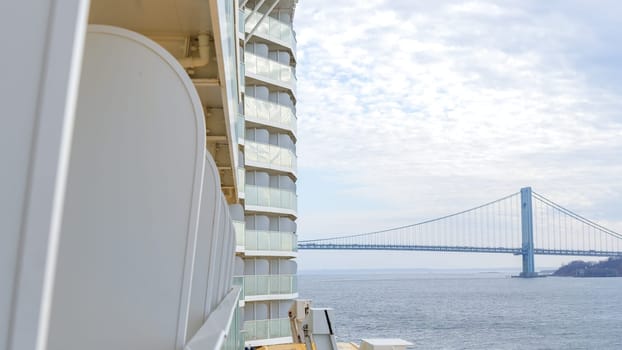 Modern cruise ship passing under the bridge with a beautiful sky. New York NY USA - 09.02.2024.