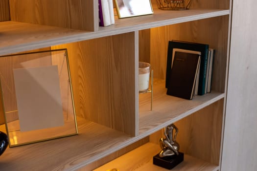 A shelving with figurines, frames, books with warm lighting. Copy space. Mock up
