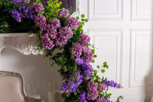Lavish floral arrangement on elegant white mantel in classic interior design setting.