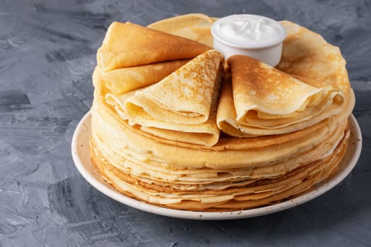 Stack of traditional russian pancakes blini on gray background. Homemade russian thin pancakes blini. Russian food, russian kitchen.