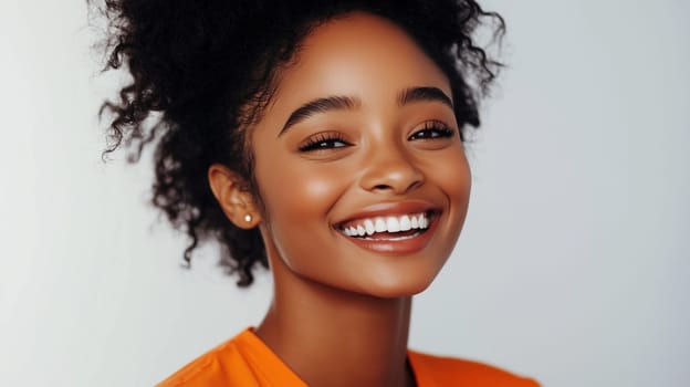 Portrait of happy young black American woman smiles, joyful African girl looking at camera standing on gray background