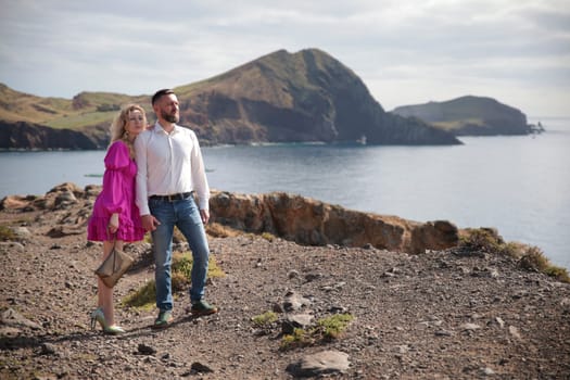 Couple standing on a cliff, enjoying the breathtaking view of ponta de s o louren o in madeira, portugal