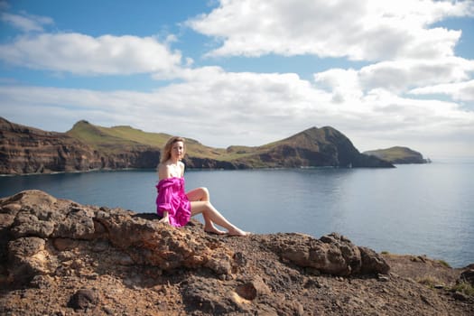 Fashion blogger enjoying breathtaking views of the atlantic ocean from rocky cliffs in madeira
