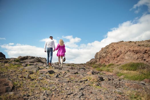 Couple walking on rocky path holding hands in madeira island, portugal