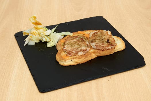 A plate of food with a sandwich and a side of vegetables. The sandwich is cut in half and has a side of vegetables on the plate