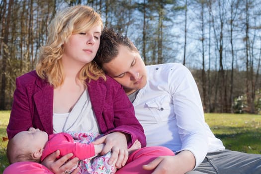 Young family is having  nice time with their baby on a sunny day
