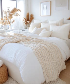A bright and cozy bedroom featuring a wooden bed, soft linens, knitted poufs, and natural decor in neutral tones. Interior photo concept