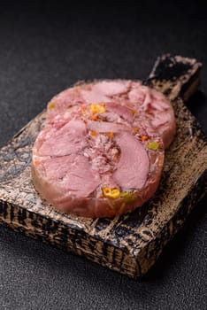 Homemade brawn with salt, spices, herbs and vegetables on a dark concrete background