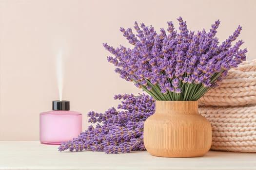 A lavender bouquet in a wooden vase with an aroma diffuser and cozy knit blankets. Soft, natural tones for a relaxing atmosphere. Interior photo concept