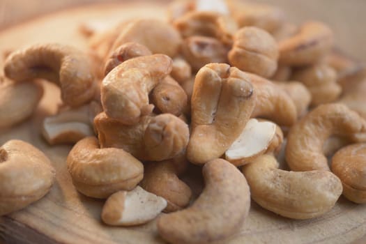 Fresh cashews scattered on a wooden surface, perfect for recipes.