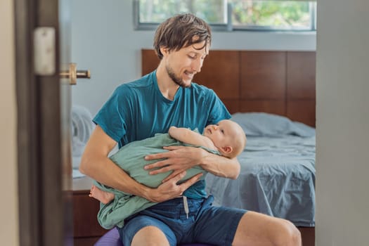 A father sits on a fitness ball in a cozy bedroom, gently rocking his baby wrapped in a soft muslin swaddle. A nurturing and soothing moment of fatherhood and care. Parenting, bonding, and comfort concept.